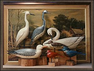 A display of wood sculptures by Rick Heller, many life size, of many types of water birds from a brochure.